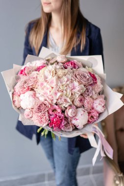 Pembe şakayık ve ortanca. Kadın elinde karışık çiçek güzel buket. Çiçek dükkanı konsepti . Yakışıklı taze buket. Çiçek teslimatı. Kırmızı ve pembe renk.