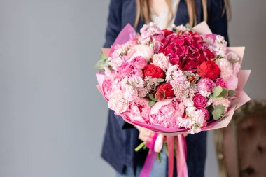 Pembe şakayıkve kırmızı ortanca. Kadın elinde karışık çiçek güzel buket. Çiçek dükkanı konsepti . Yakışıklı taze buket. Çiçek teslimatı. Kırmızı ve pembe renk.