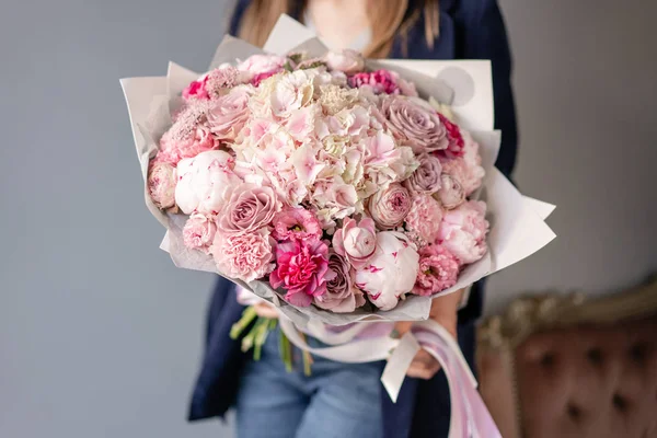 Peonías rosadas y hortensia. Hermoso ramo de flores mixtas en mano de mujer. Concepto de tienda floral. Bonito ramo fresco. Entrega de flores. Color rojo y rosa . — Foto de Stock
