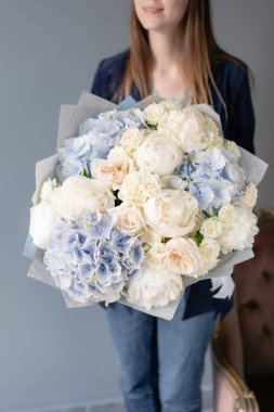 Beyaz şakayık ve mavi ortanca. Kadın elinde karışık çiçek güzel buket. Çiçek dükkanı konsepti . Yakışıklı taze buket. Çiçek teslimatı