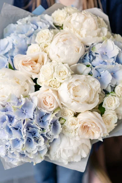 Білі півонії і блакитна гортензія. Красивий букет змішаних квітів в руці жінки. Концепція квіткового магазину. Гарний свіжий букет. Доставка квітів — стокове фото