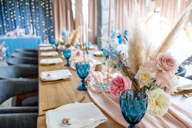 lüks yemek ziyafet restoranda. Güzel ve zarif dekorasyon düğün kutlama. Bej pembe masa örtüsü, tabak ve şamdanlar mumlar ile ziyafet hizmet tablo.