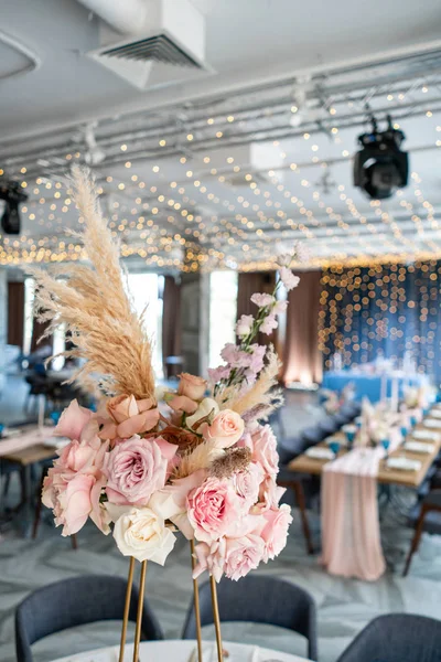 結婚披露宴やガラ ・ ディナー。椅子とお客様は、テーブル、カトラリー、食器類を添えてください。パステル ピンクのテーブル クロス ランナーで覆われています。花輪ライトアップ パーティー — ストック写真