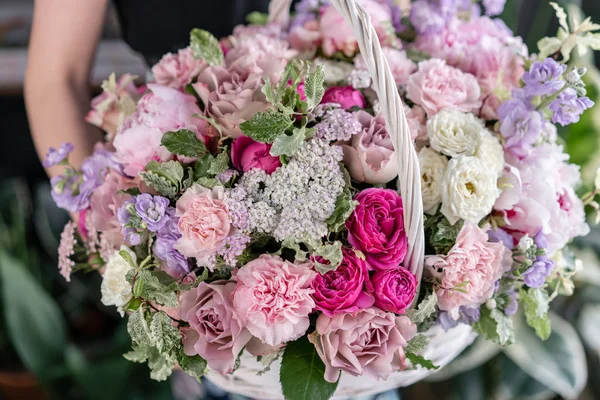 Flower arrangement in Wicker basket. Beautiful bouquet of mixed flowers in woman hand. Floral shop concept . Handsome fresh bouquet. Flowers delivery — Stock Photo, Image