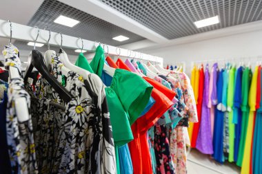 Kokteyl elbisesi. Modern mağaza butik askı giyim. Parlak çok renkli kumaşlar. alışveriş kavramı.