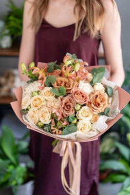 Kadın elinde güzel bir buket karışık çiçek. Çiçek dükkanı konsepti. Güzel, taze bir buket. Çiçek teslimatı.