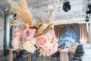 Düğün ya da gala yemeği. Sandalye ve masa için konuklar, çatal bıçak takımı ve çanak çömlek ile servis edilir. Pastel pembe masa örtüsü runner ile kaplı. çelenk ile ışıklı parti