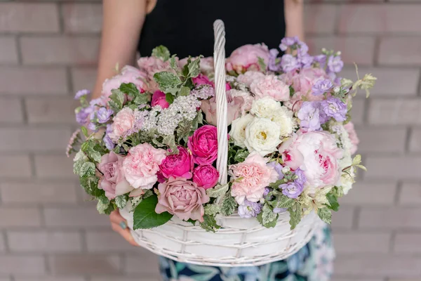 Arranjo de flores na cesta de vime. Belo buquê de flores mistas na mão da mulher. Conceito de loja floral. Bonito buquê fresco. Entrega de flores — Fotografia de Stock