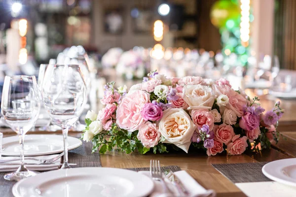 Şarap bardakları ön planda. Düğün Ziyafeti ya da gala yemeği. Misafirler için sandalye ve masa, çatal bıçak takımı ve tabak ile servis.