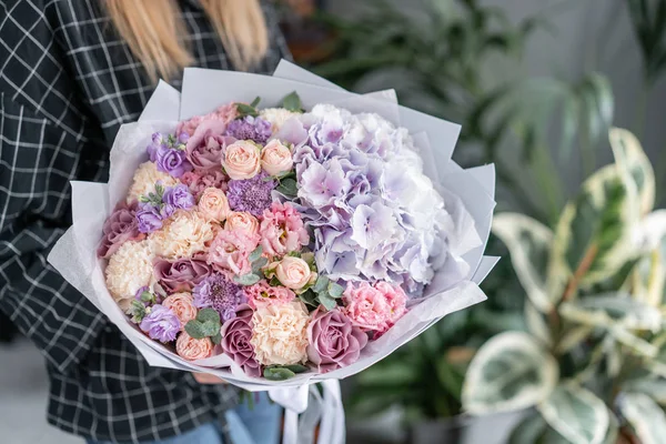 Hermoso ramo de flores mixtas en mano de mujer. Concepto de tienda floral. Bonito ramo fresco. Entrega de flores. Color rojo y rosa . — Foto de Stock