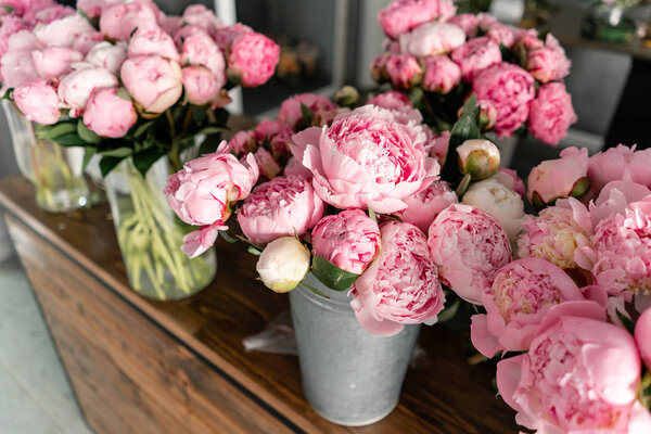 The counter of the flower shop. Pink peonies in a metal vase. Beautiful peony flower for catalog or online store. Floral shop concept . Beautiful fresh cut bouquet. Flowers delivery