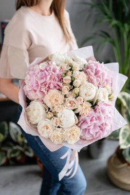 Beyaz şakayık ve pembe ortanca. Kadın elinde karışık çiçek güzel buket. Çiçek dükkanı konsepti . Yakışıklı taze buket. Çiçek teslimatı. Kırmızı ve pembe renk.