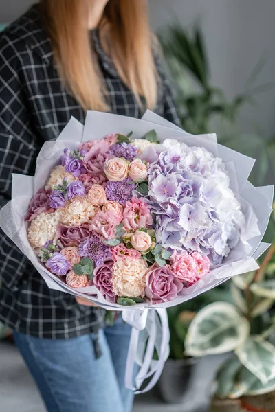 美丽的花束混合花在女人的手。花卉店概念。漂亮的新鲜花束。鲜花运送。红色和粉红色. — 图库照片