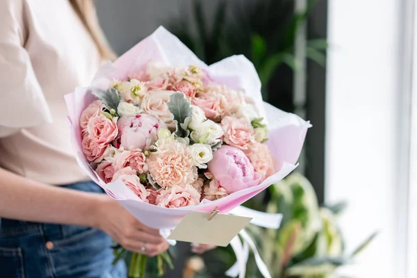 Peonías rosadas. Hermoso ramo de flores mixtas en mano de mujer. Concepto de tienda floral. Bonito ramo fresco. Entrega de flores. Color rojo y rosa . — Foto de Stock