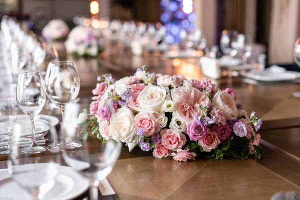 Şarap bardakları ön planda. Düğün Ziyafeti ya da gala yemeği. Misafirler için sandalye ve masa, çatal bıçak takımı ve tabak ile servis.