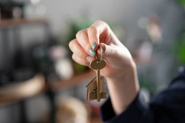 Bir daire kiralama kavramı. Ev anahtarı, kadın ların elinde. Genç bir kadın. Modern ışık lobisi iç mekan. Gayrimenkul, varsayım, eve taşınma veya mülk kiralama.