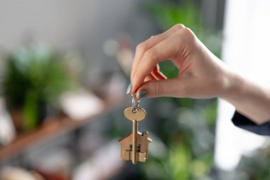 Bir daire kiralama kavramı. Ev anahtarı, kadın ların elinde. Genç bir kadın. Modern ışık lobisi iç mekan. Gayrimenkul, varsayım, eve taşınma veya mülk kiralama.