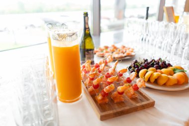 Resepsiyon büfedeki. Bardak şarap ve şampanya. Kanepeler ahşap tahta üzerinde ürün yelpazesine. Ziyafet Servisi. Gıda catering, peynir, jamon, prosciutto ve meyve ile aperatifler
