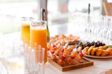 Resepsiyon büfedeki. Bardak şarap ve şampanya. Kanepeler ahşap tahta üzerinde ürün yelpazesine. Ziyafet Servisi. Gıda catering, peynir, jamon, prosciutto ve meyve ile aperatifler