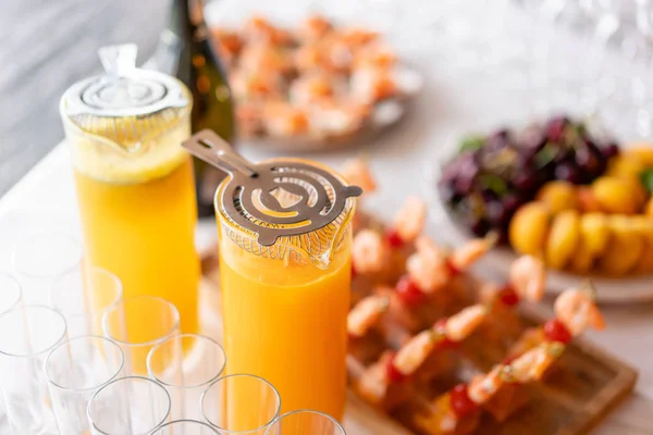 Banco di vetro di limonata con agrumi tagliati a fette su un tavolo di buffet. Festa estiva all'aperto. Disintossicazione . — Foto Stock