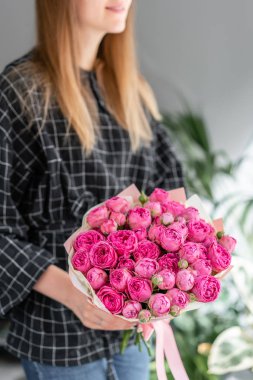 Pembe ve mor güller. Kadın elinde karışık çiçek güzel buket. Çiçek dükkanı konsepti . Yakışıklı taze buket. Çiçek teslimatı.