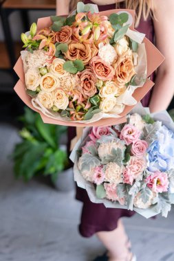 Kadın elinde karışık çiçek iki güzel buketleri. Çiçek dükkanı konsepti . Yakışıklı taze buket. Çiçek teslimatı.