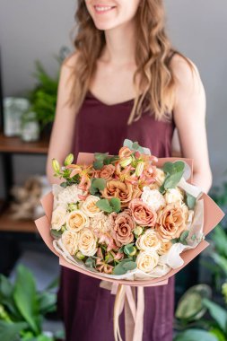 Kadın elinde güzel bir buket karışık çiçek. Çiçek dükkanı konsepti. Güzel, taze bir buket. Çiçek teslimatı.