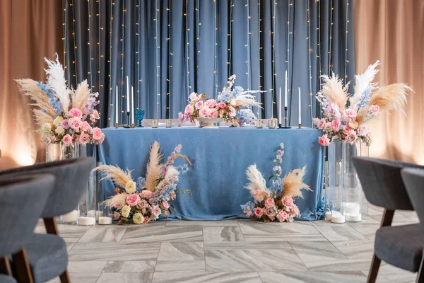 Kék terítő, tányérok és gyertyatartók gyertyákkal. Luxus vacsora bankett az étteremben. A nászünnepség gyönyörű és gyönyörű díszítése. — Stock Fotó