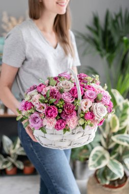 Wicker sepetinde çiçek aranjmanı. Kadın elinde karışık çiçek güzel buket. Çiçek dükkanı konsepti . Yakışıklı taze buket. Çiçek teslimatı