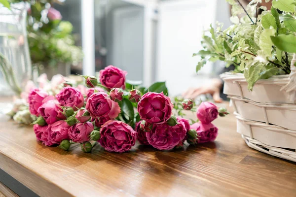 Güzel, taze bir buket. Çiçek teslimatı. Çiçekçi kadın sepette çiçek aranjmanı yapıyor. Güzel bir buket karışık çiçek. Çiçek dükkanı konsepti .