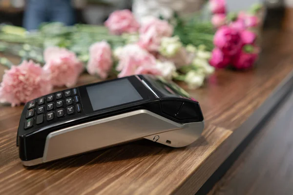 Concept contactless payment. Making payment with smartphone and pos terminal, printed check. Floral shop concept . Flowers delivery