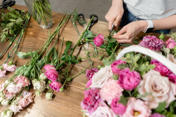 Mujer florista crear arreglo floral en una canasta de mimbre. Hermoso ramo de flores mixtas. Concepto de tienda floral. Bonito ramo fresco. Entrega de flores — Foto de Stock