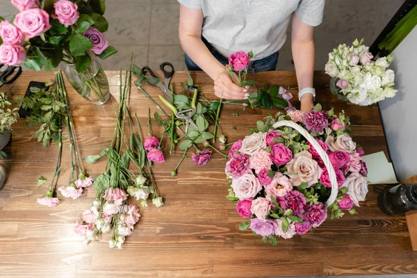 Mujer florista crear arreglo floral en una canasta de mimbre. Hermoso ramo de flores mixtas. Concepto de tienda floral. Bonito ramo fresco. Entrega de flores — Foto de Stock