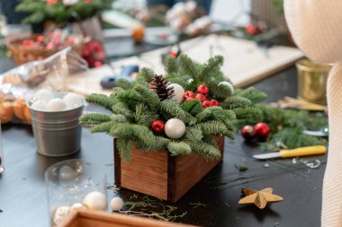 Kendi elleriyle Noel dekoru. Kadın bir xmas düzenlemesi yarattı. Dekoratif süsler yapımında master class. Çiçekçi dükkanı