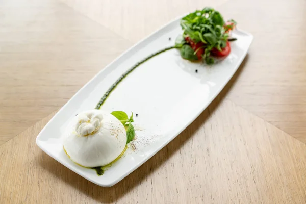 Salada fresca com tomate, manjericão, burrata e azeite sobre fundo de madeira. Salada caprese tradicional italiana. Conceito de comida mediterrânica, natural e orgânica . — Fotografia de Stock