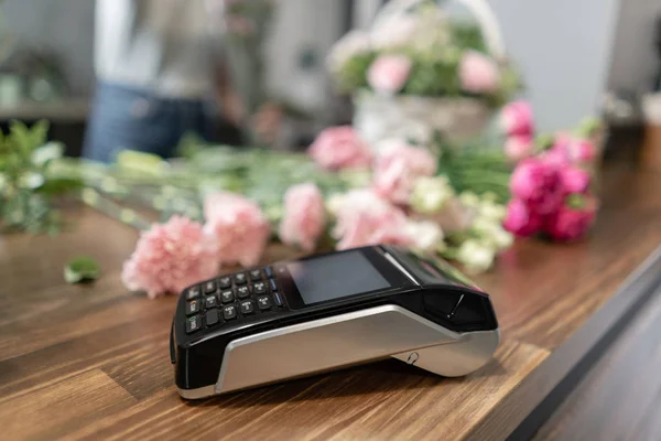 Concept contactless payment. Making payment with smartphone and pos terminal, printed check. Floral shop concept . Flowers delivery