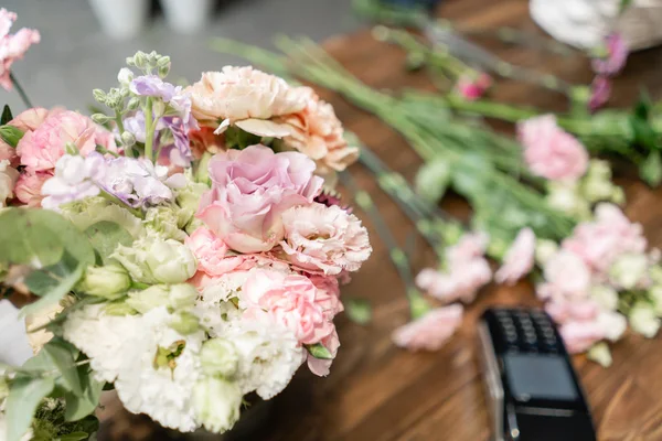 Handsome fresh bouquet. Flowers delivery. Woman florist create flower arrangement in a wicker basket. Beautiful bouquet of mixed flowers. Floral shop concept .