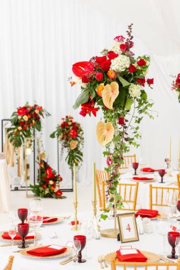 Kırmızı dekor teması. Güzel ziyafet bir düğün resepsiyonu. Misafirler için hazır bir düğün çadır dekorasyonu Iç. Dekor çiçekleri.