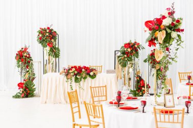 Kırmızı dekor teması. Güzel ziyafet bir düğün resepsiyonu. Misafirler için hazır bir düğün çadır dekorasyonu Iç. Dekor çiçekleri.