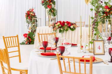 Kırmızı dekor teması. Güzel ziyafet bir düğün resepsiyonu. Misafirler için hazır bir düğün çadır dekorasyonu Iç. Dekor çiçekleri.