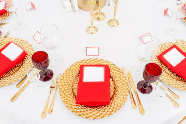 Tabel instellen rode servetten en glazen, gouden platen. Interieur van een bruiloft tent decoratie klaar voor gasten. Decor bloemen. Rode thema — Stockfoto