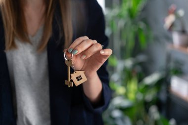 Mortgage konsepti. Genç güzel bir kadın. kadın elinde iki ev anahtarı. . Modern ışık lobisi iç mekan. Gayrimenkul, varsayım, eve taşınma veya mülk kiralama.