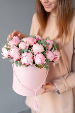 Pembe yuvarlak kutuda pembe şakayık. Katalog veya online mağaza için kadın elinde Güzel şakayık çiçek. Çiçek dükkanı konsepti. Çiçek teslimatı