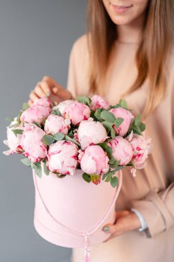 Pembe yuvarlak kutuda pembe şakayık. Katalog veya online mağaza için kadın elinde Güzel şakayık çiçek. Çiçek dükkanı konsepti. Çiçek teslimatı