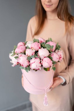 Pembe yuvarlak kutuda pembe şakayık. Katalog veya online mağaza için kadın elinde Güzel şakayık çiçek. Çiçek dükkanı konsepti. Çiçek teslimatı