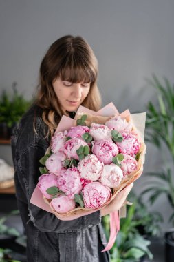 Kadın elinde pembe şakayık. Katalog veya online mağaza için güzel şakayık çiçek. Çiçek dükkanı konsepti . Güzel taze kesme buketi. Çiçek teslimatı