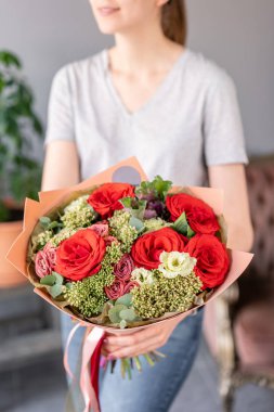 Kadın elinde karışık çiçek güzel buket. bir çiçekçi de çiçekçi çalışmaları. Taze kesilmiş çiçek.