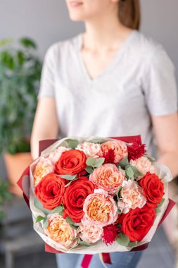 Kadın elinde karışık çiçek güzel buket. bir çiçekçi de çiçekçi çalışmaları. Taze kesilmiş çiçek.