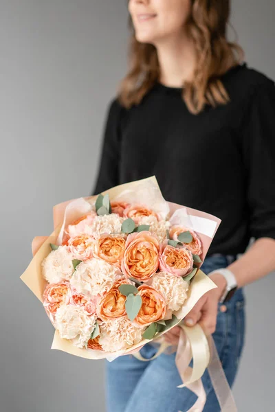 Color blanco y melocotón. Hermoso ramo de flores mixtas en manos de mujeres. el trabajo de la floristería en una florería. Flor fresca cortada . — Foto de Stock