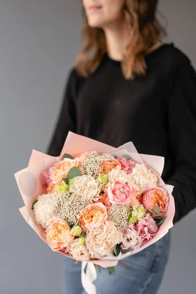 Hermoso ramo de flores mixtas en manos de mujeres. el trabajo de la floristería en una florería. Flor fresca cortada . — Foto de Stock